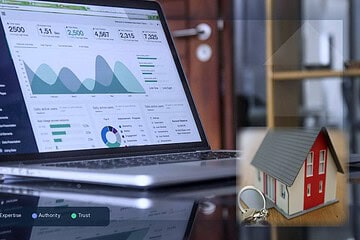 Laptop showing SEO analytics beside a model house and keys, representing E-E-A-T trust signals for real estate investor SEO