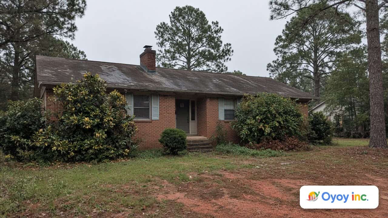 Older brick ranch house in an Atlanta suburb with a worn roof and overgrown yard, a typical motivated seller property in Georgia